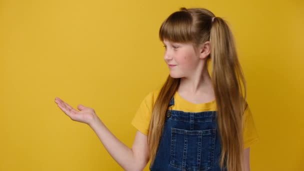 소녀는 손바닥을 공간에 손가락을 제품을 긍정적 인상을 스튜디오 고립되어 — 비디오