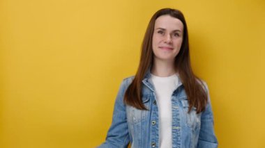 İyimser, mutlu, çekici genç bir kadın büyük beyaz hashtag sembolünü işaret ediyor ve kameraya gülümsüyor, blog trendlerinin tanıtımı, sarı arka planda izole edilmiş kot ceket giyiyor. Etiketli iletiyi oku!