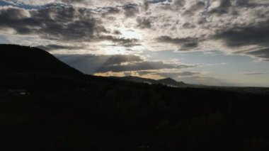 Bulutlu bir günde, ormanın üzerinde büyüleyici günbatımının inanılmaz ve şaşırtıcı drone çekimi. Dağlar, ilham verici ve muhteşem doğa, çarpıcı manzara, huzur ve huzur.