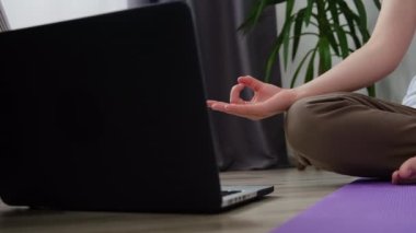 Nilüfer pozisyonunda meditasyon yapan tanınmayan bir kadın evde oturmuş, dizüstü bilgisayarından ders programını izliyor. Kız oturma odasında sabah antrenmanı yapıyor. Nilüferli kadınların elleri yerde otururken poz verir.
