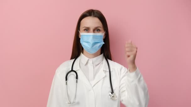 Jovem Médica Mulher Casaco Branco Médico Máscara Azul Mostrando Sinal — Vídeo de Stock