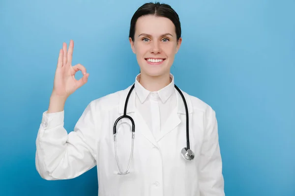 Doctor Shows Positive Smiling Woman Doctor Blue Studio Background Looking — Stock Photo, Image