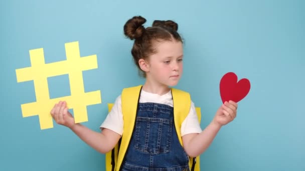 Gadis Sekolah Cantik Memegang Tagar Kuning Besar Dan Simbol Hati — Stok Video