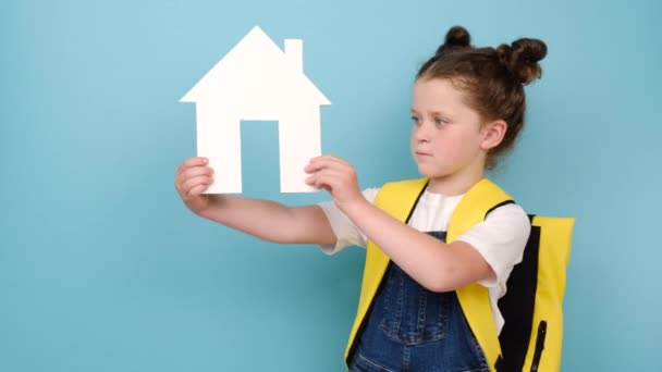 Cute Uśmiechnięta Uczennica Żółtym Plecakiem Trzymając Mały Biały Papierowy Dom — Wideo stockowe