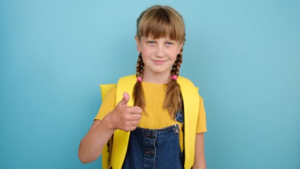 Miúdo Sorridente Menina Escola Primária Com Mochila Amarela Mostrando Polegar — Vídeo de Stock