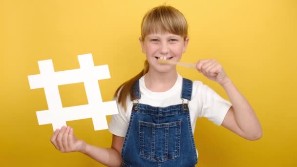 Klein Schattig Blond Kind Schoolmeisje Poetsen Tanden Houden Witte Hashtag — Stockvideo