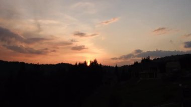 İnanılmaz dramatik turuncu gün batımının ya da kırsal kesimdeki güzel sakin dağların üzerinde güneşin doğuşunun insansız hava aracı görüntüleri. Gökyüzünün bulutlu renkleri. Siluet çam ormanı. Günbatımı manzara konsepti