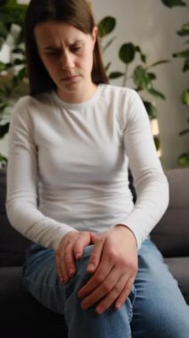 Mutsuz, üzgün, beyaz bir kadın bacağına dokunuyor diz eklemlerinde ağrı hissediyor ve iltihap ve ağrıdan dolayı düzgün yürüyemiyor. Artrit kronik hastalık sorunu kavramı