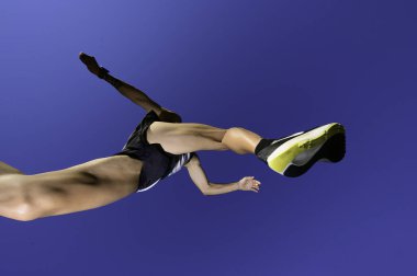 Koşucu yarış sırasında engellerden atlar