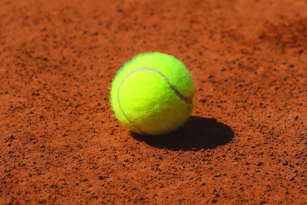 Bola de tênis em quadra de tênis de barro vermelho — Fotografia de Stock