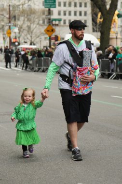 New York'taki Aziz Patrick Günü Geçit Töreni'nde yürüyen genç çocuklu aileler.