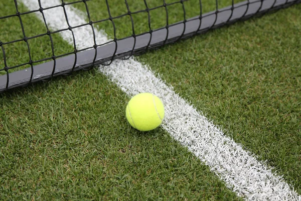 Pelota de tenis en la cancha de tenis hierba — Foto de Stock