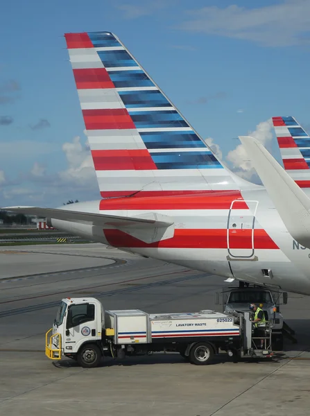 Trabajador de American Airlines elimina residuos de inodoro en el Aeropuerto Internacional de Miami — Foto de Stock