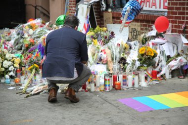 Mourner honors Orlando massacre victims at the gay rights landmark Stonewall Inn clipart