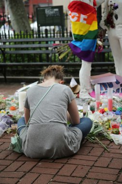 Mourners honor Orlando massacre victims at the Gay Liberation Memorial in Christopher Park clipart