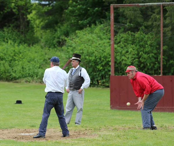 Baseball team in 19th century vintage uniform during old style base ball play following the rules and customs from 1864