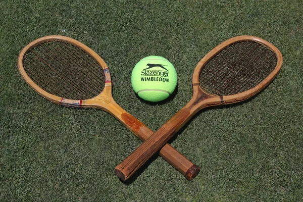 Raquetas de tenis vintage y Slazenger Wimbledon Tennis Ball en cancha de tenis de hierba —  Fotos de Stock