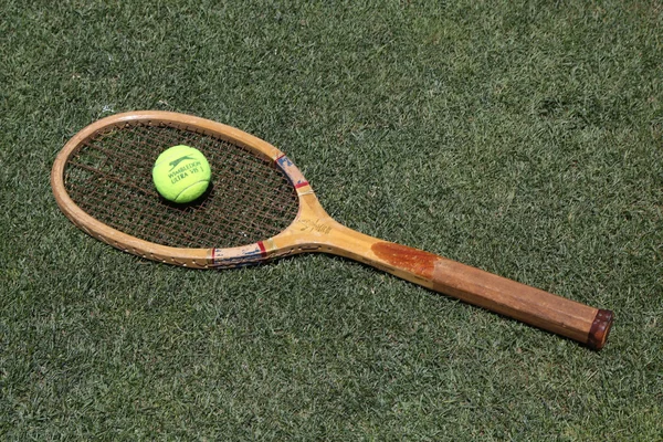 Raquete de tênis vintage e bola de tênis Slazenger Wimbledon na quadra de tênis grama — Fotografia de Stock