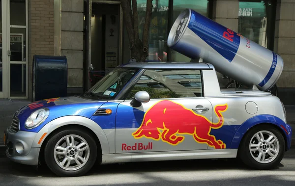 A Red Bull mini cooper publicity car with a can of Red Bull drink