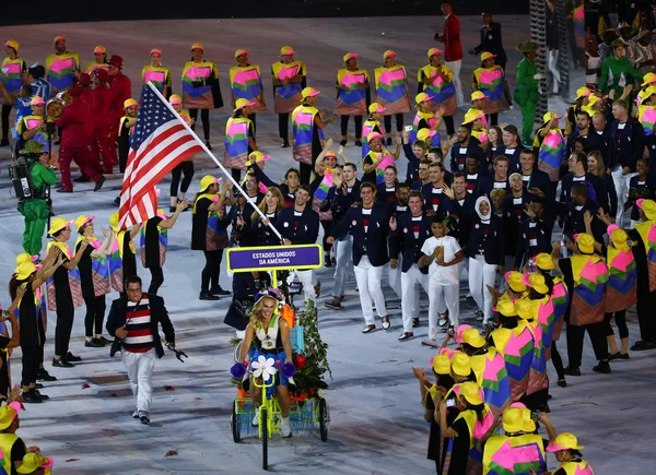 Olympiasieger michael phelps trägt die Flagge der Vereinigten Staaten, die das olympische Team USA bei der Eröffnungsfeier in Rio 2016 anführt — Stockfoto