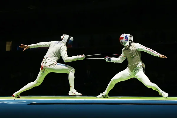 Russian fencer (L) attacks Great Britain fencer at the Men's team foil quarterfinal of the Rio 2016 Olympic Games — Stock Photo, Image