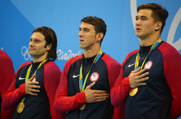 USA Men's 4x100m medley relay team Cory Miller (L),  Michael Phelps and Nathan Adrian celebrate victory at the Rio 2016 Olympic Games 