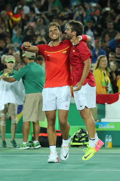 Олимпийские чемпионы Рафаэль Надаль (L) и Марк Лопес (Испания) празднуют победу в мужском парном разряде финала Олимпийских игр Рио-2016 в Олимпийском теннисном центре — стоковое фото