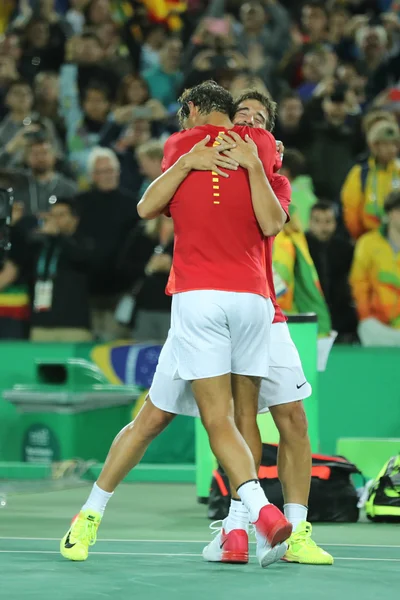 Campeões olímpicos Rafael Nadal (L) e Mark Lopez da Espanha celebram vitória nas duplas masculinas dos Jogos Olímpicos Rio 2016 no Centro Olímpico de Tênis — Fotografia de Stock