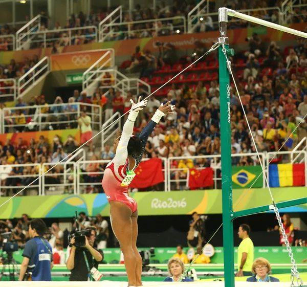 米国のオリンピックチャンピオンシモーネ・バイルズは、リオ2016オリンピックで女子チームオールラウンド体操で不均一なバーで競います — ストック写真