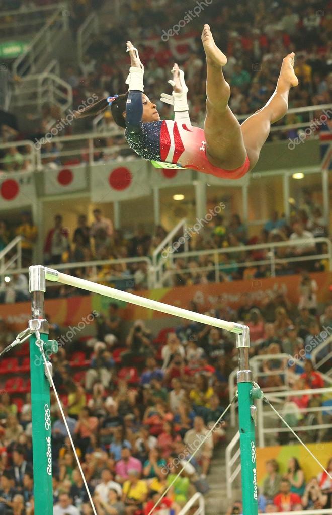 RIO DE JANEIRO, BRAZIL - AUGUST 9, 2016: Olympic champion Simone Biles of United States competes on the uneven bars at women's team all-around gymnastics at Rio 2016 Olympic Games at Rio Olympic Arena