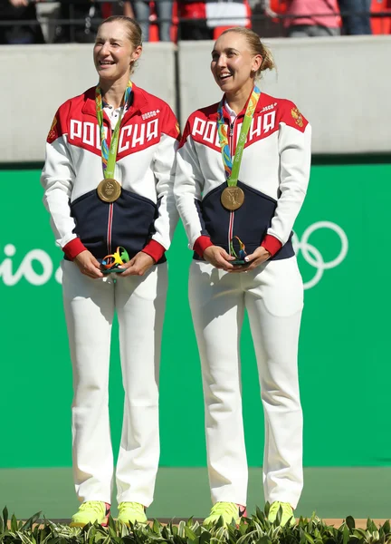 Olympijští vítězové tým Ruska Jekatěrina Makarovová (L) a Elena Vesninová během ceremoniálu udělování medailí po tenisové čtyřhře konečné — Stock fotografie