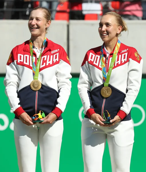 Olympijští vítězové tým Ruska Jekatěrina Makarovová (L) a Elena Vesninová během ceremoniálu udělování medailí po tenisové čtyřhře konečné — Stock fotografie