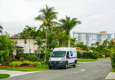 HALLANDALE BEACH, FLORIDA - APRIL 21, 2021: United States Postal Service van at Golden Isles neighborhood in Hallandale Beach, Florida clipart
