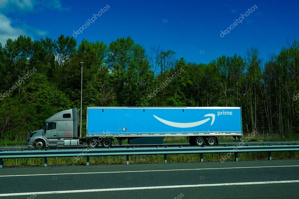 STATEN ISLAND, NEW YORK - MAY 5, 2021: Amazon truck driving on the freeway, the large Prime logo printed on the side
