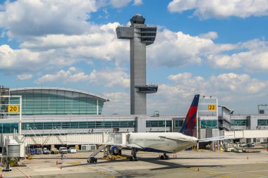 NEW YORK - 16 Mayıs 2019: Hava Trafik Kontrol Kulesi ve Delta Havayolları uçağı JFK Uluslararası Havaalanı 'ndaki Terminal 4' te pistte. JFK, 4 pisti ve 8 terminali olan dünyanın en büyük havaalanlarından biridir.