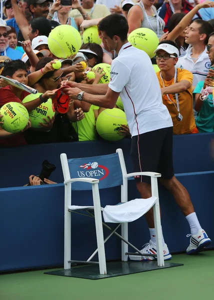 Six fois champion du Grand Chelem Novak Djokovic signe des autographes après le match de l'US Open 2014 — Photo