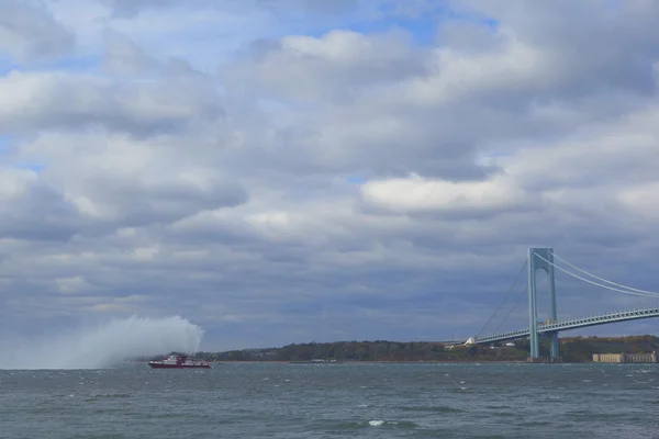 FDNY Fireboat sprays water into the air to celebrate the start of New York City Marathon 2014 in the front of Verrazano Bridge — Stock Photo, Image