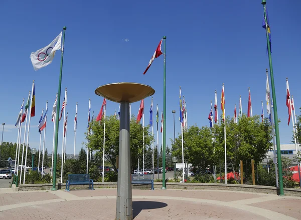 Olympic Cauldron och internationella flaggor i Kanada Olympic Park i Calgary — Stockfoto