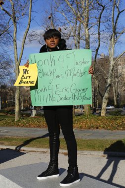 Bir protestocu bir işareti bir yürüyüş sırasında polis vahşeti ve büyük jüri karara Eric Garner davasında karşı Grand Army Plaza Brooklyn üzerinde tutar