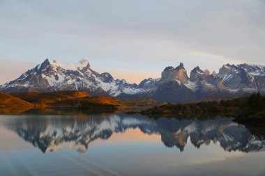 Cliffs of Los Kuernos reflection during sunrise at Lake Pehoe in National Park Torres del Paine clipart