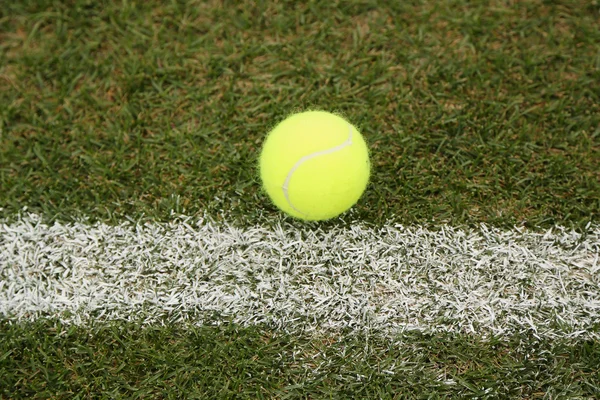 Pelota de tenis en la cancha de tenis hierba — Foto de Stock