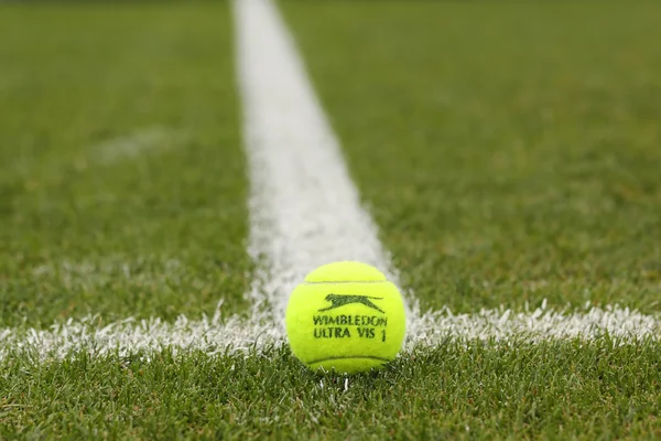 Slazenger Wimbledon pelota de tenis en la pista de tenis de hierba . —  Fotos de Stock