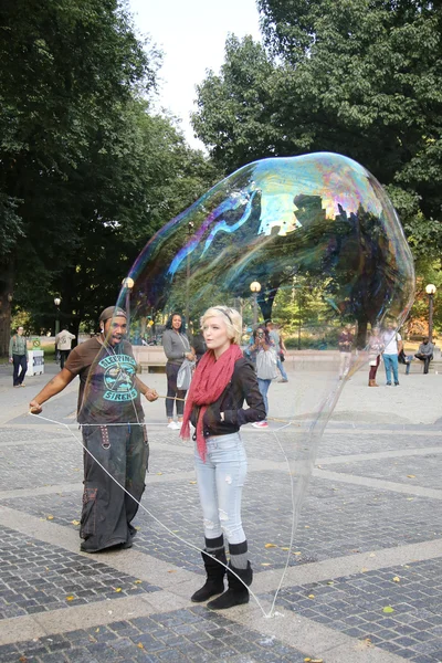 Street performer creating oversize bubbles for kids at Central Park in New York — Stock Photo, Image