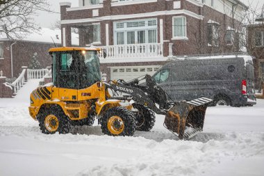 BrooKLYN, New York - 25 Ocak 2025: Büyük bir kış fırtınası bölgeyi kaplamaya devam ederken, New York 'taki bir yerleşim yerinden ağır kar temizleyen bir ön yükleyici
