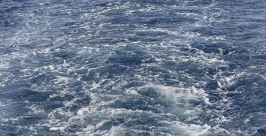 Dalgalı bir tekne dalgası. Deniz dalgası. Yat yelken açıyor, arkasında iz ve dalgalar bırakıyor..