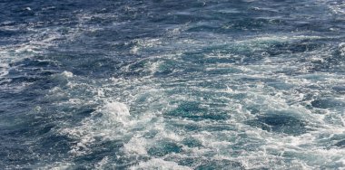 Dalgalı bir tekne dalgası. Deniz dalgası. Yat yelken açıyor, arkasında iz ve dalgalar bırakıyor..