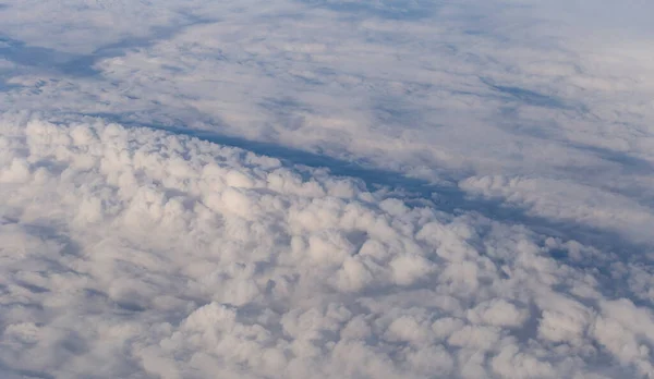 stock image Stratosphere, a view of clouds from an airplane window.  Cumuliform cloudscape on sky. Flying over the land.