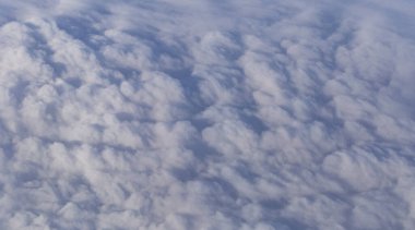 Stratosfer, bir uçak penceresinden bulutların görüntüsü. Gökyüzünde kümüliform bulutları. Arazinin üzerinde uçarken.