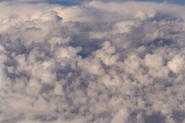 Stratosfer, bir uçak penceresinden bulutların görüntüsü. Gökyüzünde kümüliform bulutları. Arazinin üzerinde uçarken.