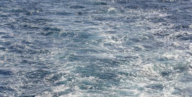 Dalgalı bir tekne dalgası. Deniz dalgası. Yat yelken açıyor, arkasında iz ve dalgalar bırakıyor..